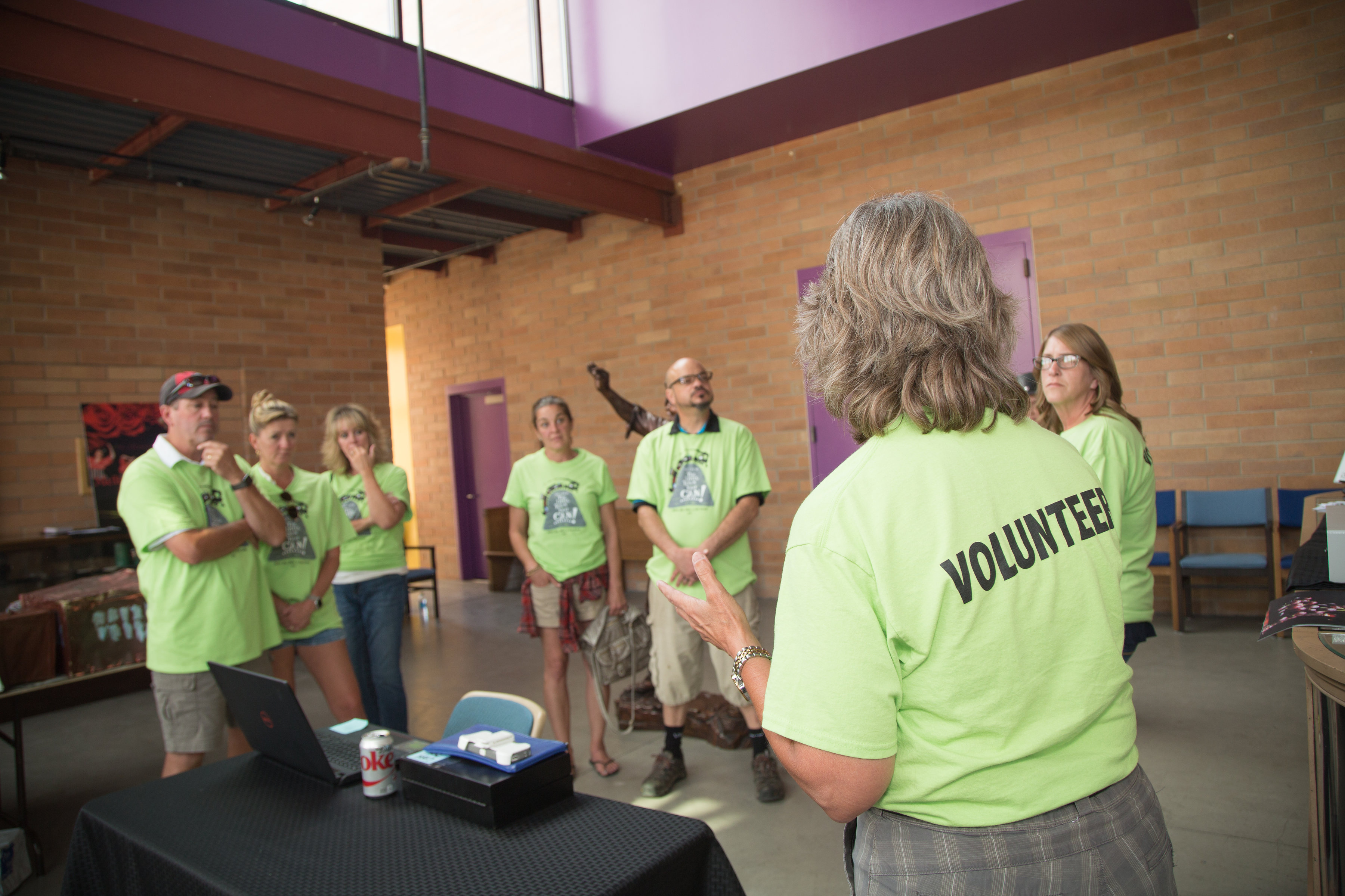 Festival volunteers in green shirts gathered for a briefing